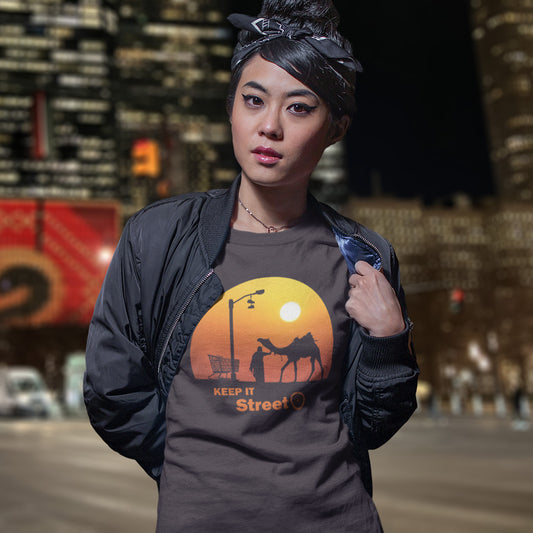 Person wearing a t-shirt featuring a sunset design , standing in an urban setting. This humorous, underground stencil art represents inner city street life as a culture of it's own. There is a ground level reality mixed with trustworthy honestly at street level in towns and cities across the planet. Wherever you are in the world, may the street be with you. Made from 100% organic ring-spun cotton, this street art t-shirt is unisex, high-quality, super comfy, and best of all, eco-friendly.