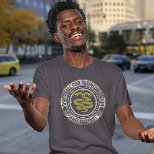 Man wearing a t-shirt with a snake logo and text in an urban setting. A non conformist t shirt design. Call it SPIN, LIES or GASLIGHTING , It's all misinformation. There's a lot of it about these days and most of it seems to be coming from above. Made from 100% organic ring-spun cotton, this social awareness t-shirt is unisex, high-quality, super comfy, and best of all, eco-friendly.