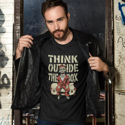 Man wearing a black t shirt with 'think outside the box' text. A think outside the box t shirt to promote diversity of thought. Trust the ventriloquist dummy to know thinking outside the box is liberating and progressive. Promote independent and creative thinking with this unique urban art design. Made from 100% organic ring-spun cotton, this counter culture t shirt is unisex, high quality, super comfy, and best of all, eco-friendly.