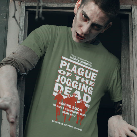 Person wearing a green t-shirt with 'Plague of the Jogging Dead' text and graphics, standing in a doorway. A satirical t-shirt about jogging in a horror movie design. Just when you thought it was safe to go out for a nice relaxing walk. Made from 100% organic ring-spun cotton, this social awareness t-shirt is unisex, high-quality, super comfy, and best of all, eco-friendly.