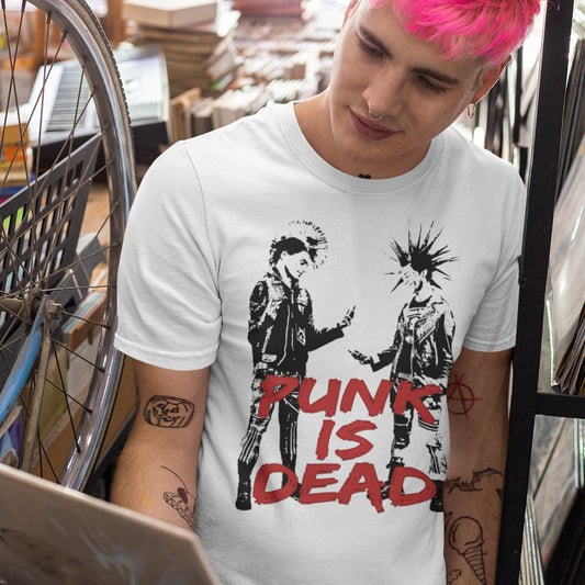 Man in shop. This controversial design questions the slogan, 'Punks not dead' by suggesting that our ever increasing reliance on mobile phones is a level of conformity and acceptance of enforced technological advancements. This is not what you expect from the free world and punks on smart phones just doesn't look right. Made from 100% organic ring-spun cotton, this counterculture t-shirt is unisex, high-quality, super comfy, and best of all, eco-friendly.