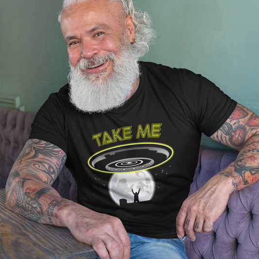 A smiling man sat down and wearing a black t shirt with a spaceship design and "TAKE ME" text.
