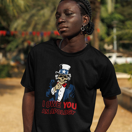 A person wearing a black graphic t-shirt with a cartoon Uncle Sam design and the text 'I LOVE YOU AN APOLOGY' in red and white, set against a blurred outdoor background.