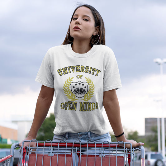 A woman wearing a cream-colored graphic t-shirt with a gold and black 'UNIVERSITY OPEN MINDS' design, standing behind a red shopping cart in an outdoor parking lot.