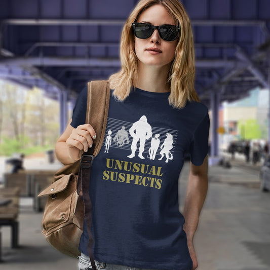 Woman standing under a bridge wearing a French navy t shirt with "UNUSUAL SUSPECTS" text.
