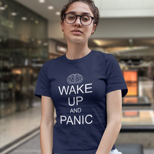 A woman in glasses, wearing a French navy blue, short sleeved, crew neck t-shirt with a white graphic text "WAKE UP AND PANIC".