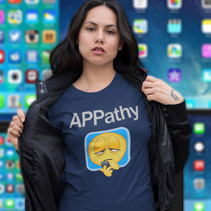 Person wearing a French navy blue t-shirt with 'APPathy' design in front of a colourful app icon background. This anti mobile phone abuse t shirt promotes social awareness of the amount of apps we now need in modern society. This unique emoji t-shirt design is for everyone who doesn't feel they are a child of the mobile phone. Made from 100% organic ring-spun cotton, this anti smart phone abuse t shirt is unisex, high-quality, super comfy, and best of all, eco-friendly.