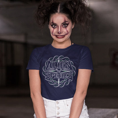 Person wearing a navy blue t-shirt with 'Alien Species' design, posing against a blurred background. This non conformist t shirt expands the use of the word 'Alien'. This design is ideal for everyone that feels they don't truly relate to the rest of humankind and modern society. Made from 100% organic ring-spun cotton, this counter culture t-shirt is unisex, high-quality, super comfy, and best of all, eco-friendly.