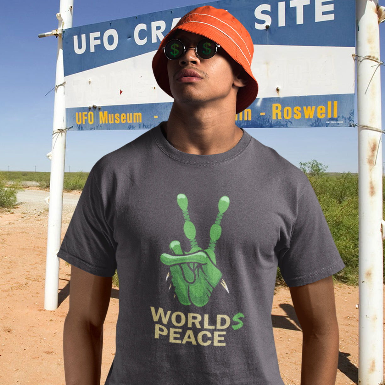 Man wearing a worlds peace t shirt at Roswell site. A world peace t shirt with an alien lovers twist. When we think of world peace lets not be selfish about it., lets include all Worlds. Made from 100% organic ring-spun cotton, this funny alien t shirt is unisex, high-quality, super comfy, and best of all, eco-friendly.
