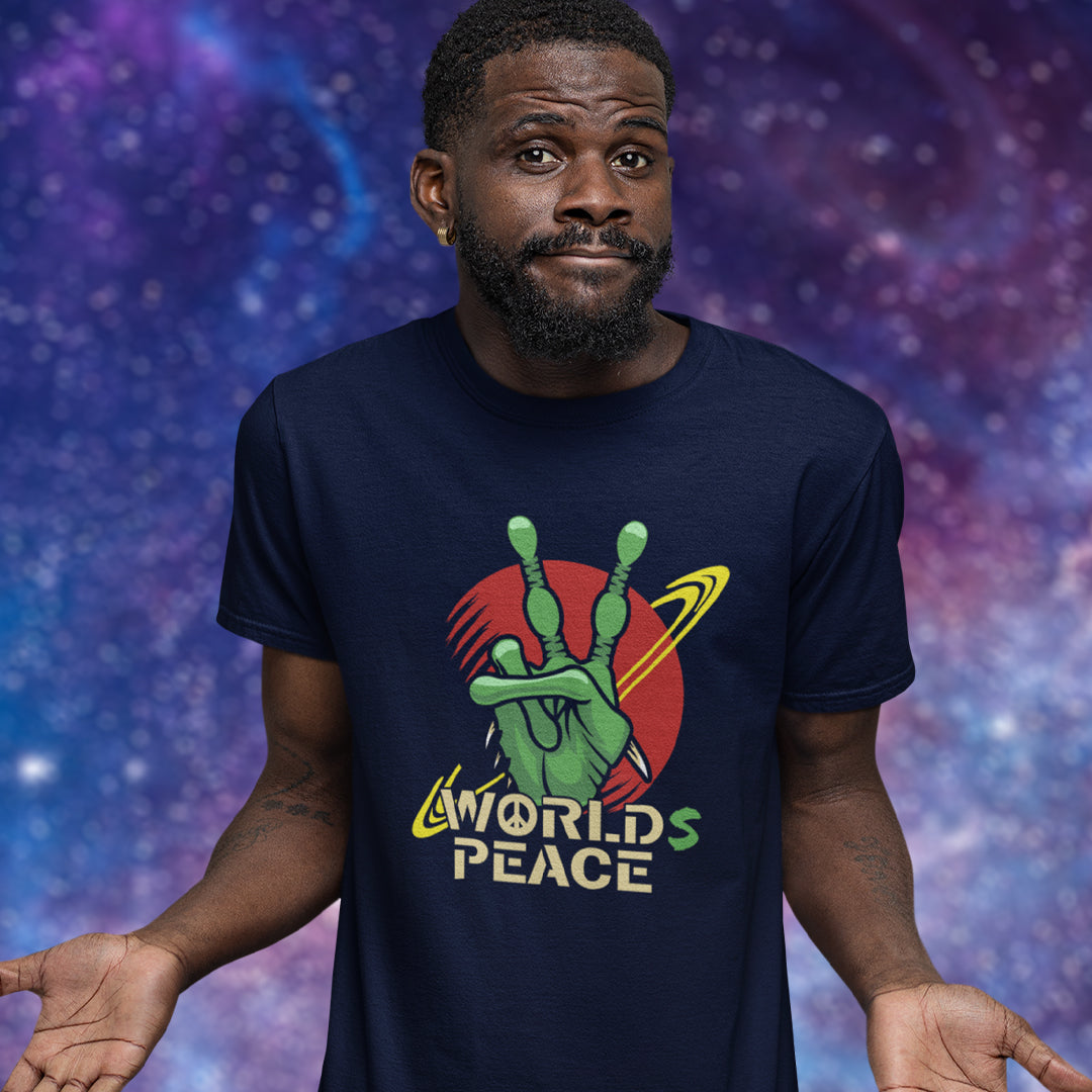 A man wearing a navy blue graphic t-shirt with a green hand making a peace sign in front of a purple and blue starry galaxy background. The text on the shirt reads 'WORLD'S PEACE'.