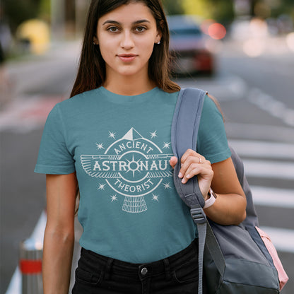 Young woman standing in the street, wearing a stargazer blue t-shirt with "ANCIENT ASTRONAUT THEORIST" logo.