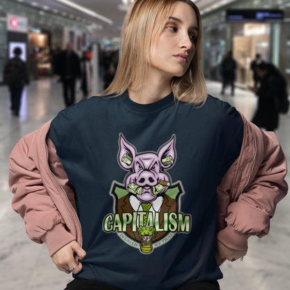 Person wearing a navy blue sweatshirt with a pig graphic and 'CAPITALISM' text in a mall. An anti-capitalism t-shirt depicting greed and money worship as our downfall. It's greed we worship now, not God. Made from 100% organic ring-spun cotton, this non conformist t shirt is unisex, high-quality, super comfy, and best of all, eco-friendly.