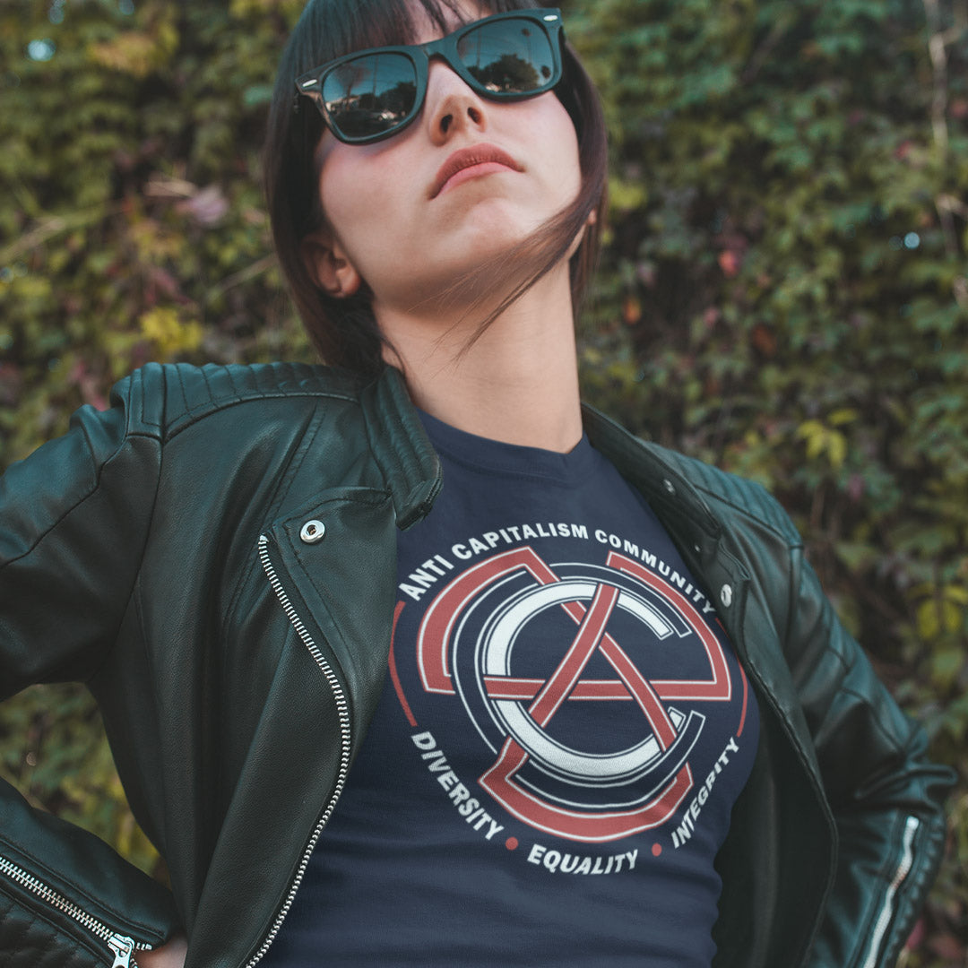 Person wearing a dark jacket and sunglasses with a graphic t-shirt in front of green foliage. This anti establishment t shirt speaks out against capitalism and promotes diversity, equality and integrity. Capitalism is responsible for so many of societies problems, do not accept it. Join our community and be proud to wear the shirt. Made from 100% organic ring-spun cotton, this anti capitalist t shirt is unisex, high-quality, super comfy, and best of all, eco-friendly.