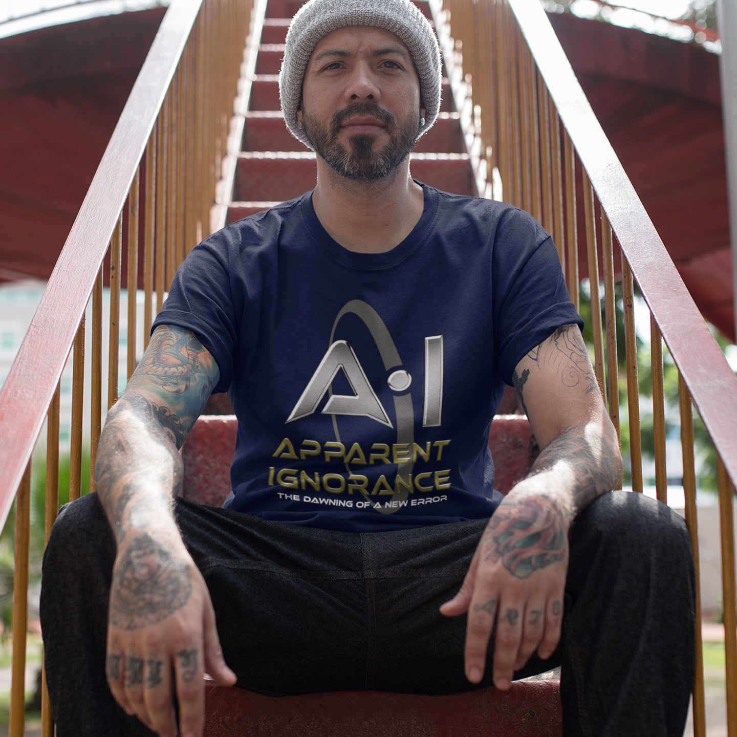Man wearing a French navy blue t-shirt with 'Apparent Ignorance' text sitting on steps. This anti ai t shirt design questions the effects of A.I on our society and suggests we are ignoring it's full effects. Whether you are concerned about technology taking people's jobs or worried about A.I doing our thinking for us. Made from 100% organic ring-spun cotton, this counter culture t shirt is unisex, high quality, super comfy, and best of all, eco-friendly.