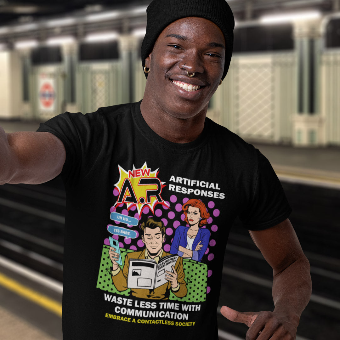 Person wearing a black t-shirt with a colorful graphic design in a subway setting. This anti ai t shirt design, in a comic book pop art style, warns against artificial intelligence taking over too many aspects of our lives. In an ever increasing dependency on artificial realities, just how far will it go ? Will our communication be artificial one day ? Satirical and sarcastic, funny but scary. Made from 100% organic ring-spun cotton, this anti ai t shirt is unisex, high-quality, super comfy, and best of all