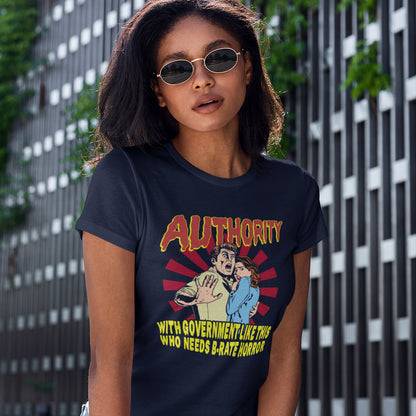 A woman wearing a navy graphic t-shirt with a retro-style cartoon illustration and the word 'AUTHORITY' in red and yellow, standing in front of a modern building with vertical slats.
