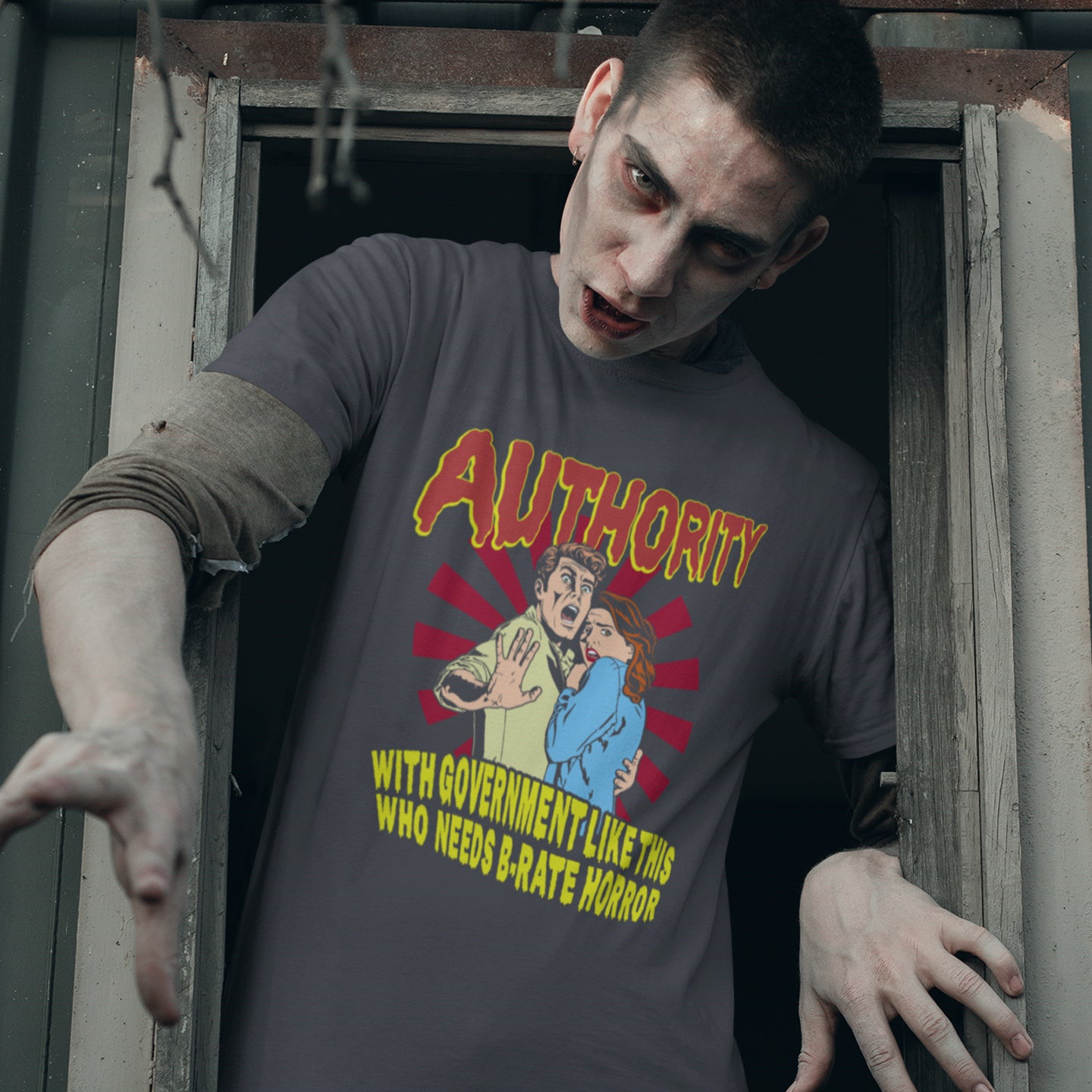 Person wearing a t-shirt with a graphic design and text, standing in a doorway. This non conformist t shirt design is portrayed in an old horror movie poster. A witty but satirical view of just how bad our governance has become and how it resembles watching a B rate horror movie. Made from 100% organic ring-spun cotton, this anti government t shirt is unisex, high-quality, super comfy, and best of all, eco-friendly.