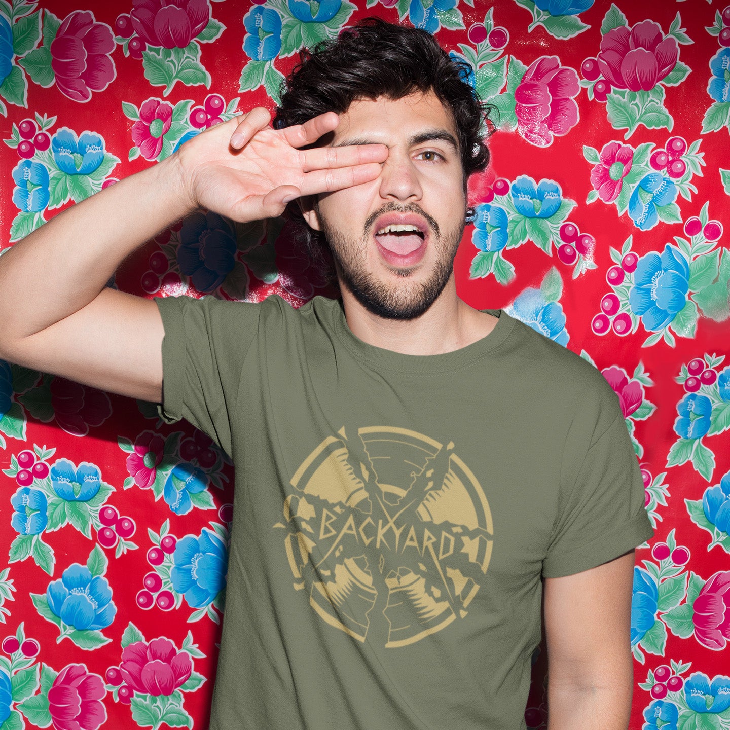 Man wearing a khaki t-shirt with a graphic design in front of a colourful floral background. A unique Backyard t-shirt. If you were there, you were there. If you know, you know and if you remember it you are lucky !! Eco friendly t shirt. Made from 100% organic ring-spun cotton, this nostalgic t-shirt is unisex, high-quality, super comfy, and best of all, eco-friendly.