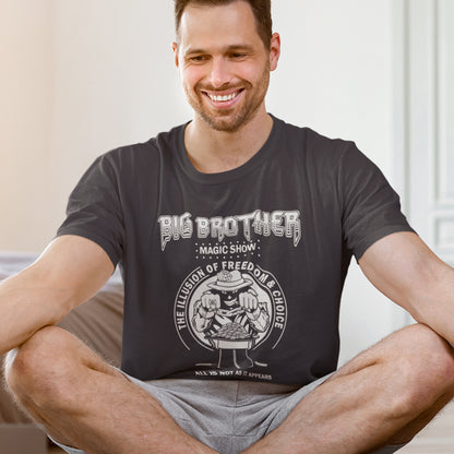 Man wearing a anthracite t-shirt with graphic design sitting on a couch. A funny conspiracy theory t-shirt suggesting our 'freedom of choice' is just part of an elaborate illusion. Magic shows are great until you realise you are living in one. This witty unique design hints at our society being distracted by greed. Made from 100% organic ring-spun cotton, this witty conspiracy theory t-shirt is unisex, high-quality, super comfy, and best of all, eco-friendly.