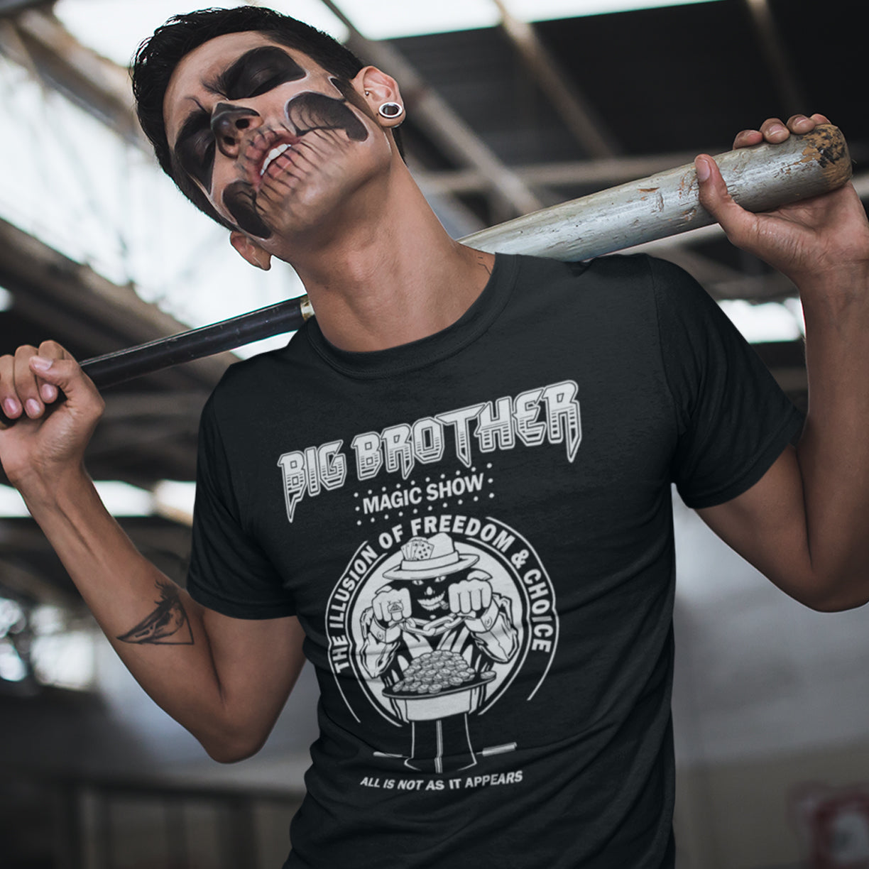 Person wearing a black t-shirt with 'Big Brother' graphic design, holding a baseball bat. A funny conspiracy theory t-shirt suggesting our 'freedom of choice' is just part of an elaborate illusion. Magic shows are great until you realise you are living in one. This witty unique design hints at our society being distracted by greed. Made from 100% organic ring-spun cotton, this witty conspiracy theory t-shirt is unisex, high-quality, super comfy, and best of all, eco-friendly.