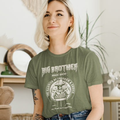Person wearing a khaki t-shirt with 'Big Brother' graphic design indoors. A funny conspiracy theory t-shirt suggesting our 'freedom of choice' is just part of an elaborate illusion. Magic shows are great until you realise you are living in one. This witty unique design hints at our society being distracted by greed. Made from 100% organic ring-spun cotton, this witty conspiracy theory t-shirt is unisex, high-quality, super comfy, and best of all, eco-friendly.