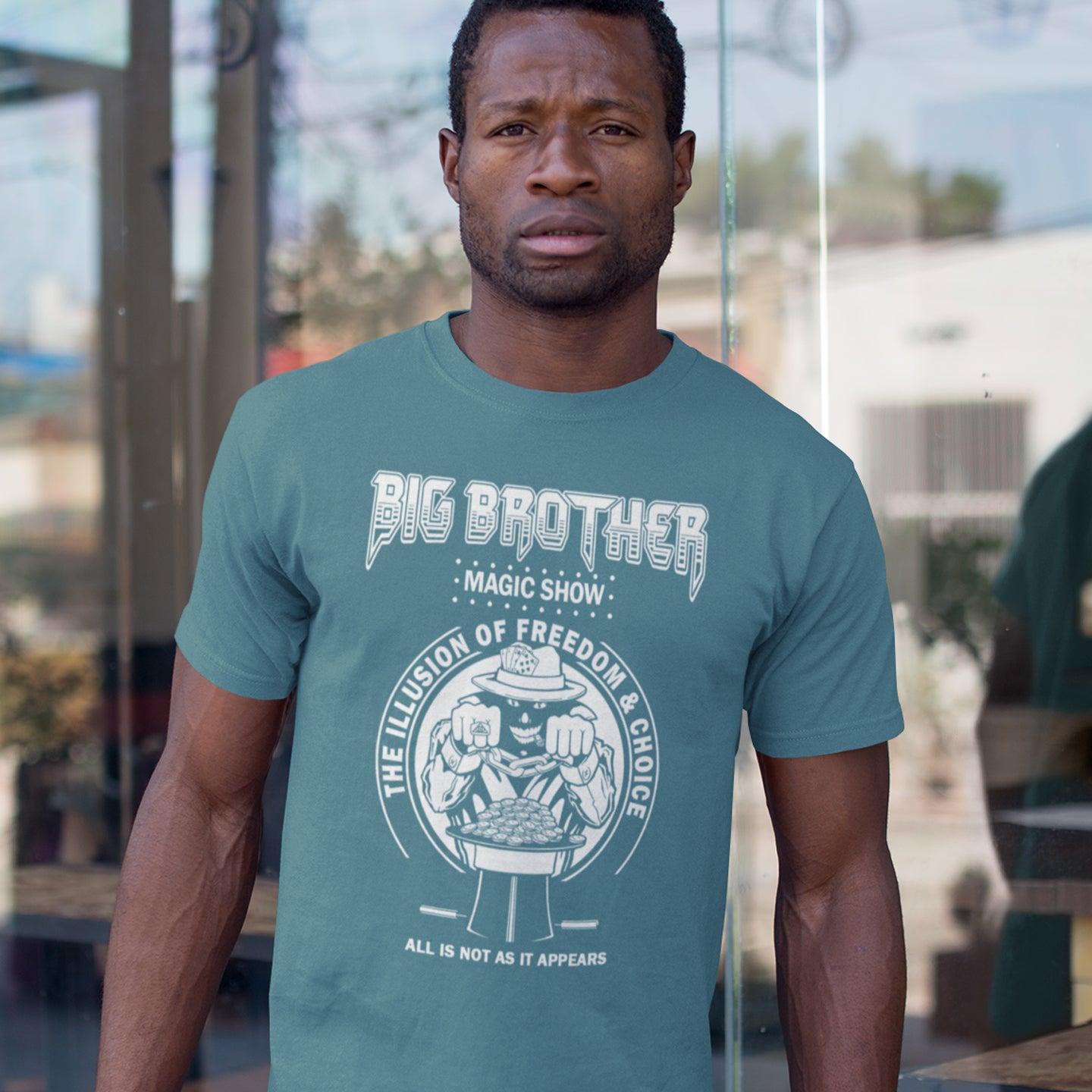 Man wearing a stargazer t-shirt with 'Big Brother' graphic design. A funny conspiracy theory t-shirt suggesting our 'freedom of choice' is just part of an elaborate illusion. Magic shows are great until you realise you are living in one. This witty unique design hints at our society being distracted by greed. Made from 100% organic ring-spun cotton, this witty conspiracy theory t-shirt is unisex, high-quality, super comfy, and best of all, eco-friendly.