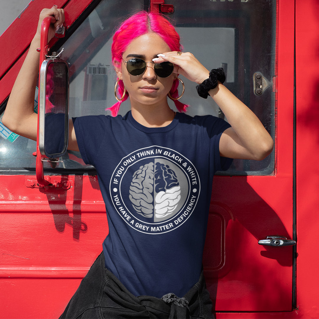 Person with pink hair wearing a blue t-shirt with a graphic design, standing next to a red vehicle. A stencil art t shirt design. It would be so easy if life was black and white, but it's the grey area where all the thinking and personal growth is done. A philosophy t shirt design for people who see the detail and can think outside the box. Made from 100% organic ring-spun cotton, this social awareness t shirt is unisex, high-quality, super comfy, and best of all, eco-friendly.