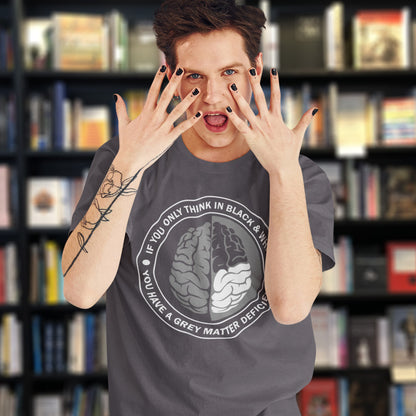 Person wearing a t-shirt with a brain graphic and text in front of a bookshelf. A stencil art t shirt design. It would be so easy if life was black and white, but it's the grey area where all the thinking and personal growth is done. A philosophy t shirt design for people who see the detail and can think outside the box. Made from 100% organic ring-spun cotton, this social awareness t shirt is unisex, high-quality, super comfy, and best of all, eco-friendly.