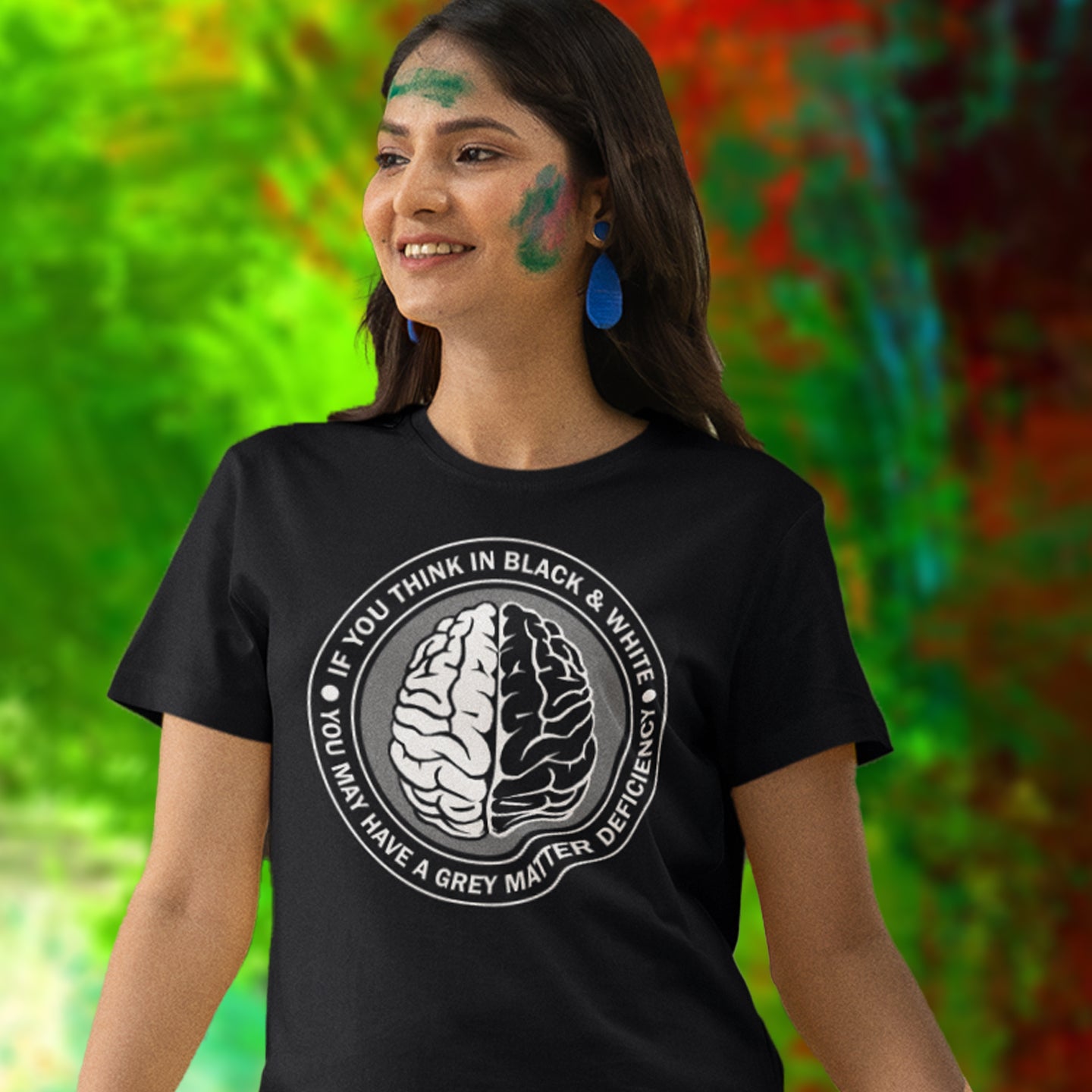 Person wearing a black t-shirt with a brain graphic and text, standing against a colorful blurred background. A stencil art t shirt design. It would be so easy if life was black and white, but it's the grey area where all the thinking and personal growth is done. A philosophy t shirt design for people who see the detail and can think outside the box. Made from 100% organic ring-spun cotton, this social awareness t shirt is unisex, high-quality, super comfy, and best of all, eco-friendly.