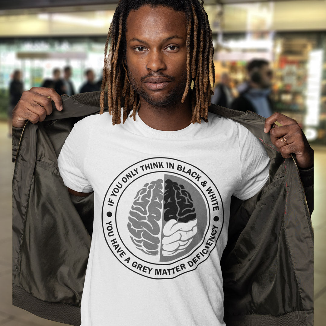 Person wearing a white t-shirt with a graphic design and text, standing in a blurred indoor setting. A stencil art t shirt design. It would be so easy if life was black and white, but it's the grey area where all the thinking and personal growth is done. A philosophy t shirt design for people who see the detail and can think outside the box. Made from 100% organic ring-spun cotton, this social awareness t shirt is unisex, high-quality, super comfy, and best of all, eco-friendly.