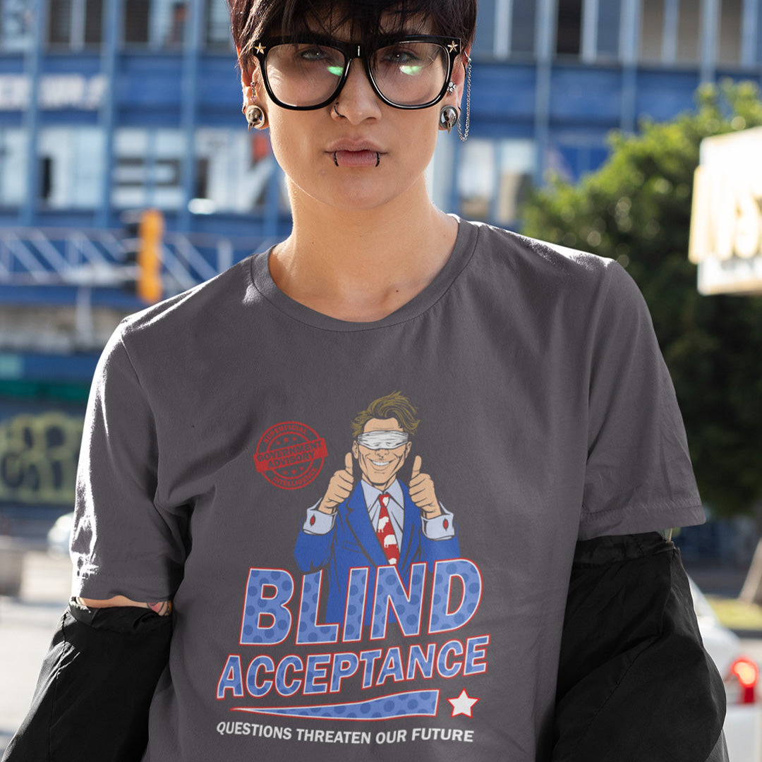 Person wearing n anthracite t-shirt with a graphic and text 'BLIND ACCEPTANCE' in an urban setting. A funny election t shirt design in a mock campaign poster style. This satirical urban art design suggests that the preferred approach to politics any government would want from their citizens is one of blind acceptance, or is this already happening ? Made from 100% organic ring-spun cotton, this anti government t shirt is unisex, high-quality, super comfy, and best of all, eco-friendly.