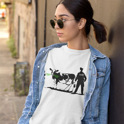 Woman wearing a white t-shirt with a graphic design of a cow and a person, standing in a crowd. A stencil graffiti t shirt showing the thin line between security and invasion of privacy, highlighted with a touch of satire and sarcasm. Made from 100% organic ring-spun cotton, this urban art t shirt is unisex, high-quality, super comfy, and best of all, eco-friendly.