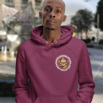 Man wearing a burgundy hoodie with a colourful emblem in an urban setting. This environmental hoodie is concerned with global warming. A design to keep climate issues at the forefront of peoples minds. A burning issue. Made from 100% organic ring-spun cotton, this environmental awareness hoodie is unisex, high-quality, super comfy, and best of all, eco-friendly.