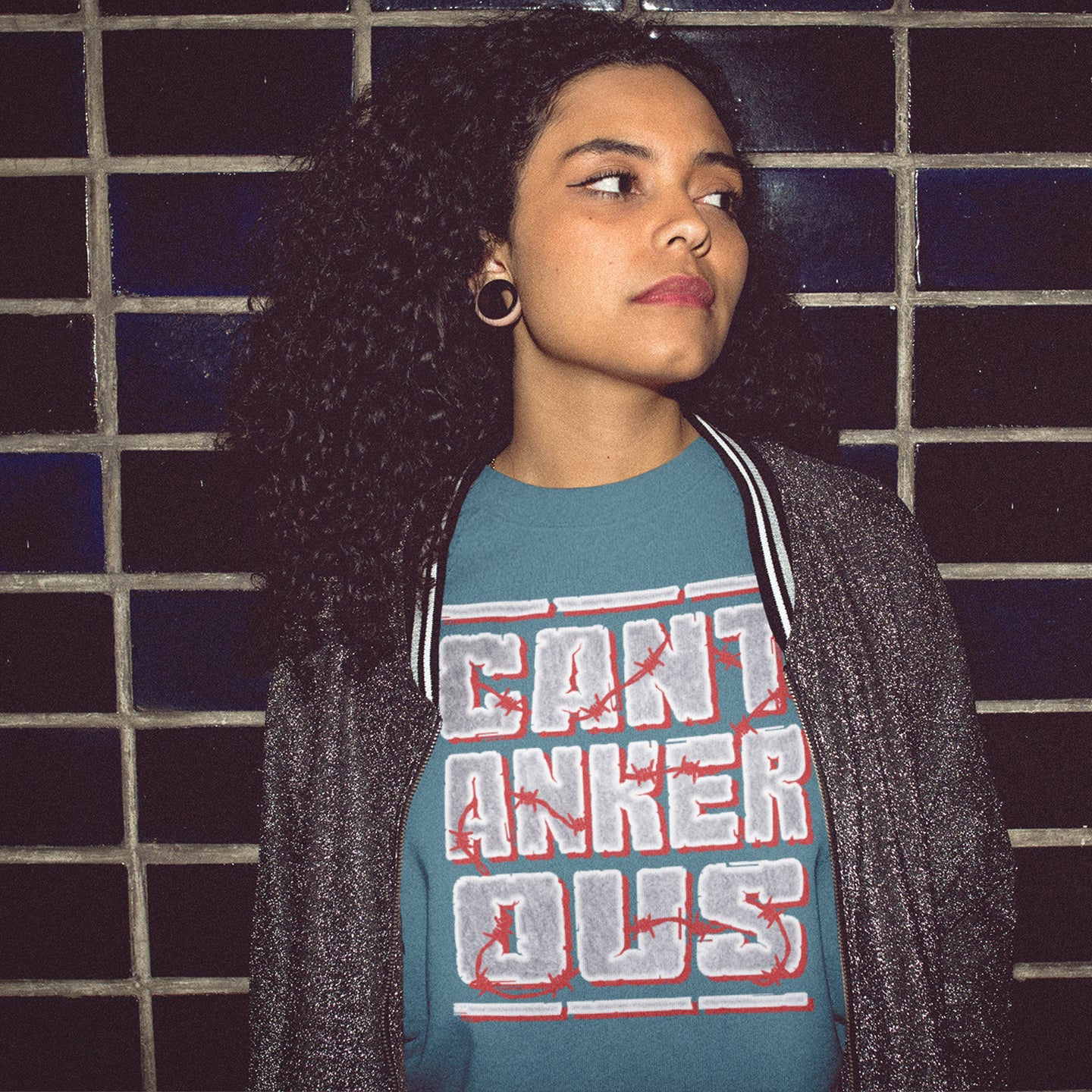 Person wearing a stargazer t-shirt with red and white text against a tiled wall. A grumpy non conformist t shirt design. Argumentative and pessimistic ? Exercise your disapproval, and be proud to be labelled cantankerous. Made from 100% organic ring-spun cotton, this urban art t shirt is unisex, high-quality, super comfy, and best of all, eco-friendly.