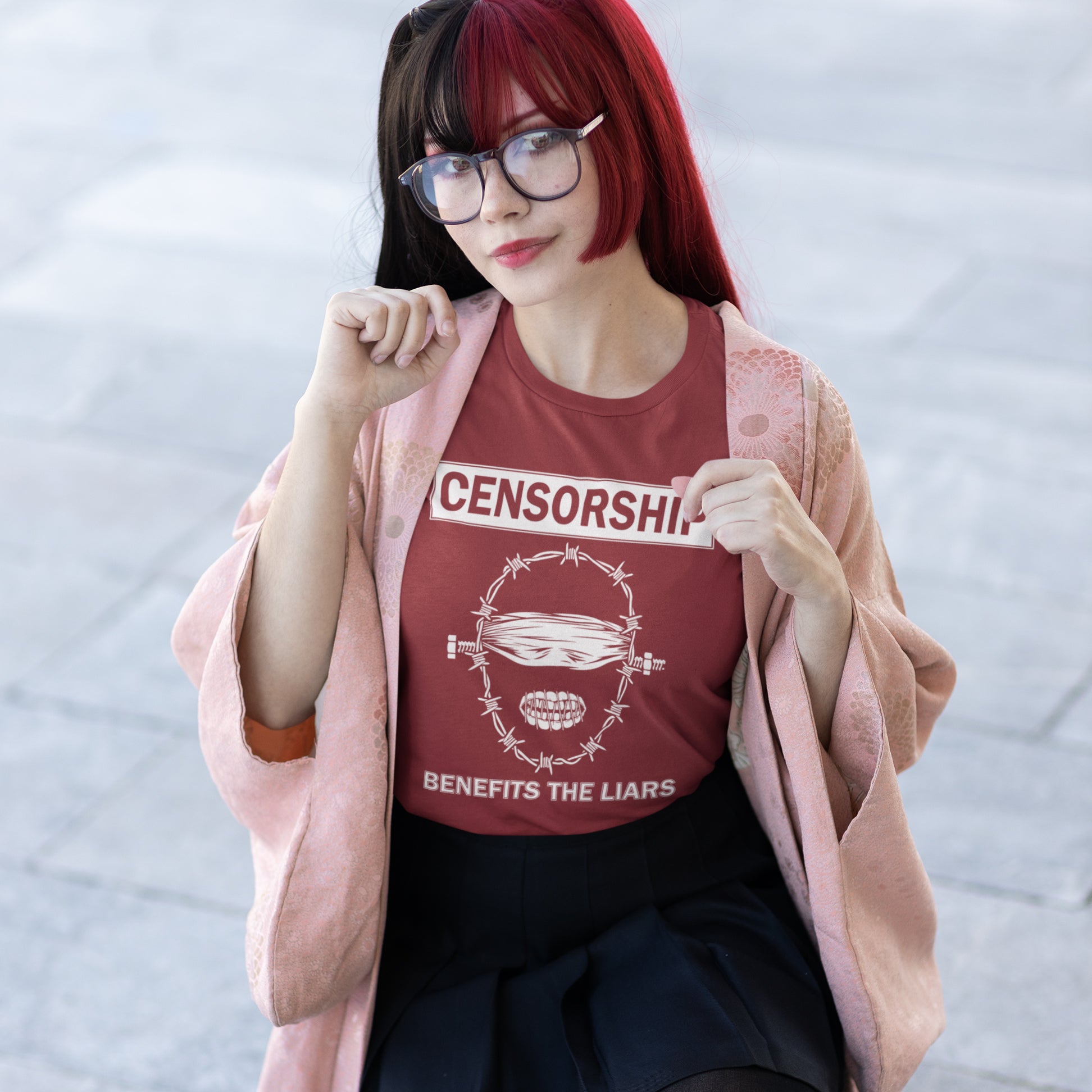 Person wearing a burgundy t-shirt with 'CENSORSHIP BENEFITS THE LIARS' text and graphic. This civil rights t shirt highlights the negative benefits of censorship. Lies and censorship go hand-in-hand as tools of control and manipulation. This unique design promotes social awareness and freedom of speech. Made from 100% organic ring-spun cotton, this no censorship t shirt is unisex, high-quality, super comfy, and best of all, eco-friendly.