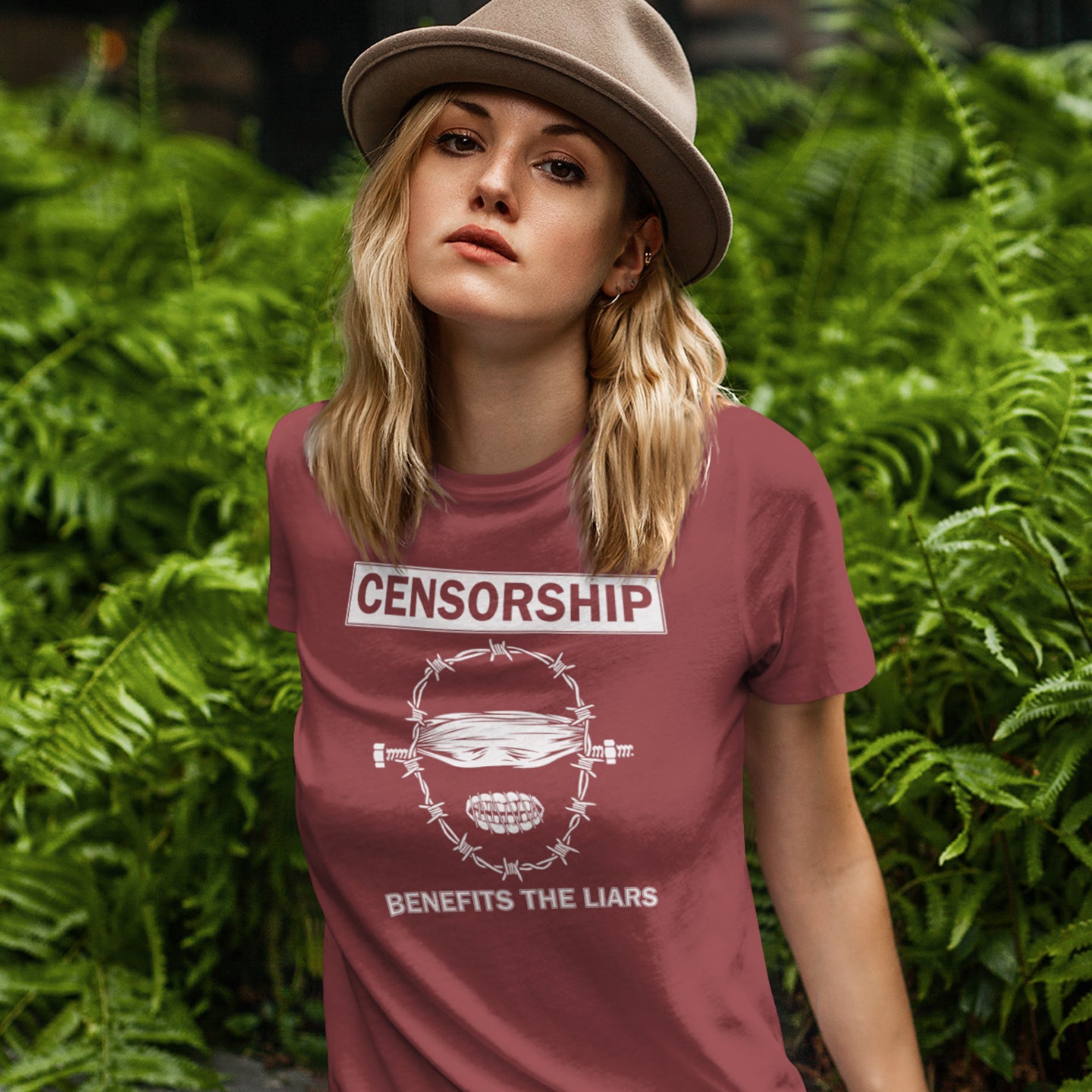 Person wearing a burgundy t-shirt with a graphic and text in front of green foliage. This political t-shirt highlights the benefits of censorship. Lies and censorship go hand-in-hand as tools of control and manipulation. This unique design promotes social awareness and freedom of speech. Made from 100% organic ring-spun cotton, this political t-shirt is unisex, high-quality, super comfy, and best of all, eco-friendly.