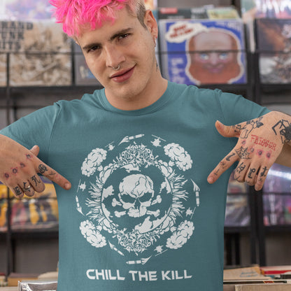 Person wearing a teal t-shirt with a skull design and 'Chill the Kill' text. An original save the planet t-shirt. A unique creation in a series of designs about environmental issues and climate concern. This one highlighting the amount of death and destruction we create as a species. Express your counterculture alternative view and encourage social awareness. Made from 100% organic ring-spun cotton, this political t-shirt is unisex, high-quality, super comfy, and best of all, eco-friendly.