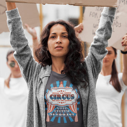 Woman holding a cardboard sign with a protest or rally setting. This anti government t shirt points out that you can change the clowns but the circus remains. Does it matter who fronts a corrupt system? The whole circus needs to go. Made from 100% organic ring-spun cotton, this civil rights t shirt is unisex, high-quality, super comfy, and best of all, eco-friendly.