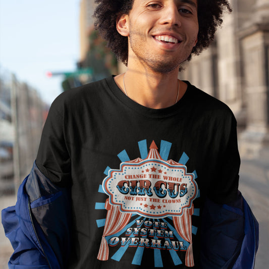 Man wearing a black sweatshirt with a colourful graphic design on a street background. This anti government t shirt points out that you can change the clowns but the circus remains. Does it matter who fronts a corrupt system? The whole circus needs to go. Made from 100% organic ring-spun cotton, this civil rights t shirt is unisex, high-quality, super comfy, and best of all, eco-friendly.