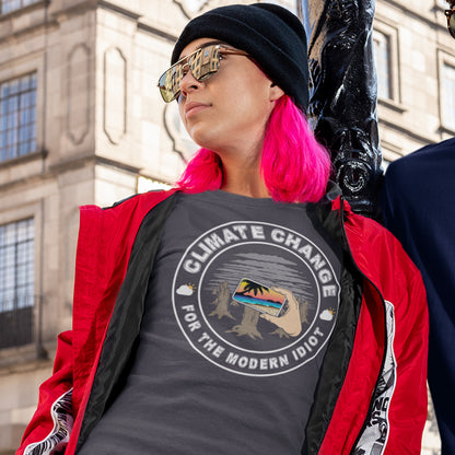 Person wearing a 'Climate Change for the Modern Idiot' t-shirt with a red jacket and black hat, standing in front of a building. A satirical save the planet t-shirt exposing the denial still opposing a very serious issue. In this age of smart technology it's surprising there isn't an app that helps us ignore the environmental crisis. Satire at it's best. Made from 100% organic ring-spun cotton, this save the world t shirt is unisex, high-quality, super comfy, and best of all, eco-friendly.