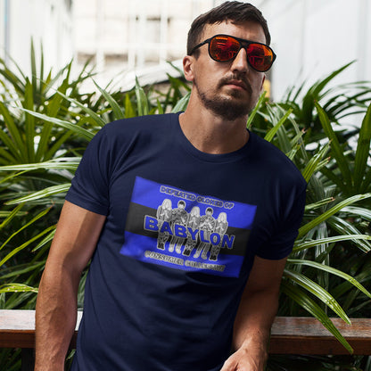 Man wearing a French navy blue t-shirt with a graphic design, sitting outdoors with plants in the background. This non conformist t shirt is for people with more than a pessimistic view of society and what we have become. This unique design has a Rastafarian hint as it suggests we fill our world with unnecessary distractions, ignoring more important issues. Made from 100% organic ring-spun cotton, this anti consumerism t shirt is unisex, high-quality, super comfy, and best of all, eco-friendly.
