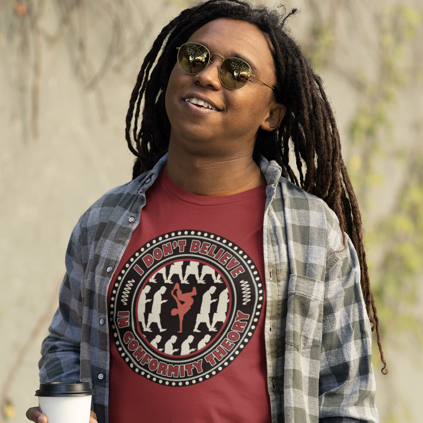 Person wearing a burgundy t-shirt with a graphic design and text, standing outdoors. An anti-conformist t-shirt promoting independent thought. Some people do what they are told without question and wait to be given their opinion. This alternative t-shirt is for the other people. This unique design helps create social awareness of diversity. Made from 100% organic ring-spun cotton, this counterculture t-shirt is unisex, high-quality, super comfy, and best of all, eco-friendly.