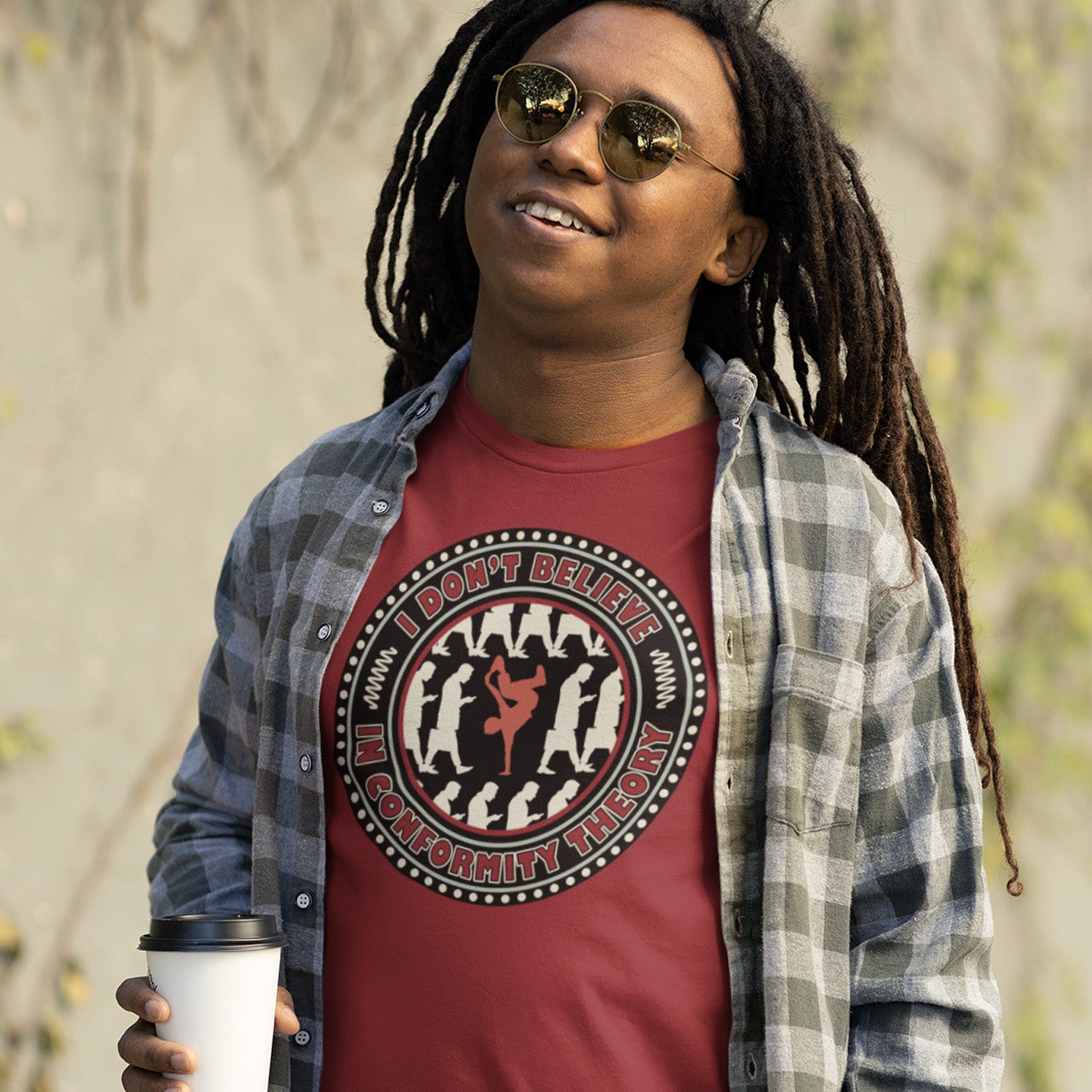 Person wearing a burgundy t-shirt with a graphic design and text, standing outdoors. A non conformist t shirt promoting independent thought. Some people do what they are told without question and wait to be given their opinion. This alternative t-shirt is for the other people. This unique design helps create social awareness of diversity. Made from 100% organic ring-spun cotton, this counter culture t shirt is unisex, high-quality, super comfy, and best of all, eco-friendly.