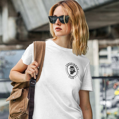 Woman wearing a white t-shirt with a logo and carrying a brown bag . A conspiracy theorist t shirt. These days there's a conspiracy theory for every occasion, join the club, expand your alternative imagination. Think outside the box. Underground art on apparel. Made from 100% organic ring-spun cotton, these conspiracy theory t shirts are unisex, high-quality, super comfy, and best of all, eco-friendly.outdoors.