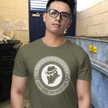 Person wearing a green t-shirt with 'Conspiracy Club' design in an industrial setting. These days there's a conspiracy theory for every occasion, join the club, expand your alternative imagination. Think outside the box. Underground art on apparel. Made from 100% organic ring-spun cotton, this conspiracy theory t-shirt is unisex, high-quality, super comfy, and best of all, eco-friendly.