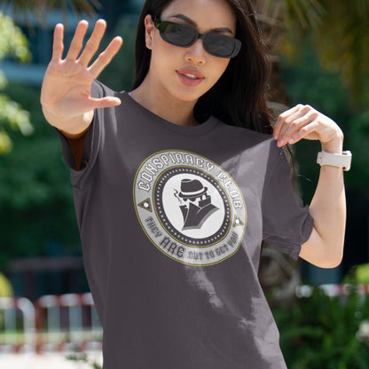 Woman wearing a t-shirt with a conspiracy theory graphic design outdoors. These days there's a conspiracy theory for every occasion, join the club, expand your alternative imagination. Think outside the box. Underground art on apparel. Made from 100% organic ring-spun cotton, this conspiracy theory t-shirt is unisex, high-quality, super comfy, and best of all, eco-friendly.