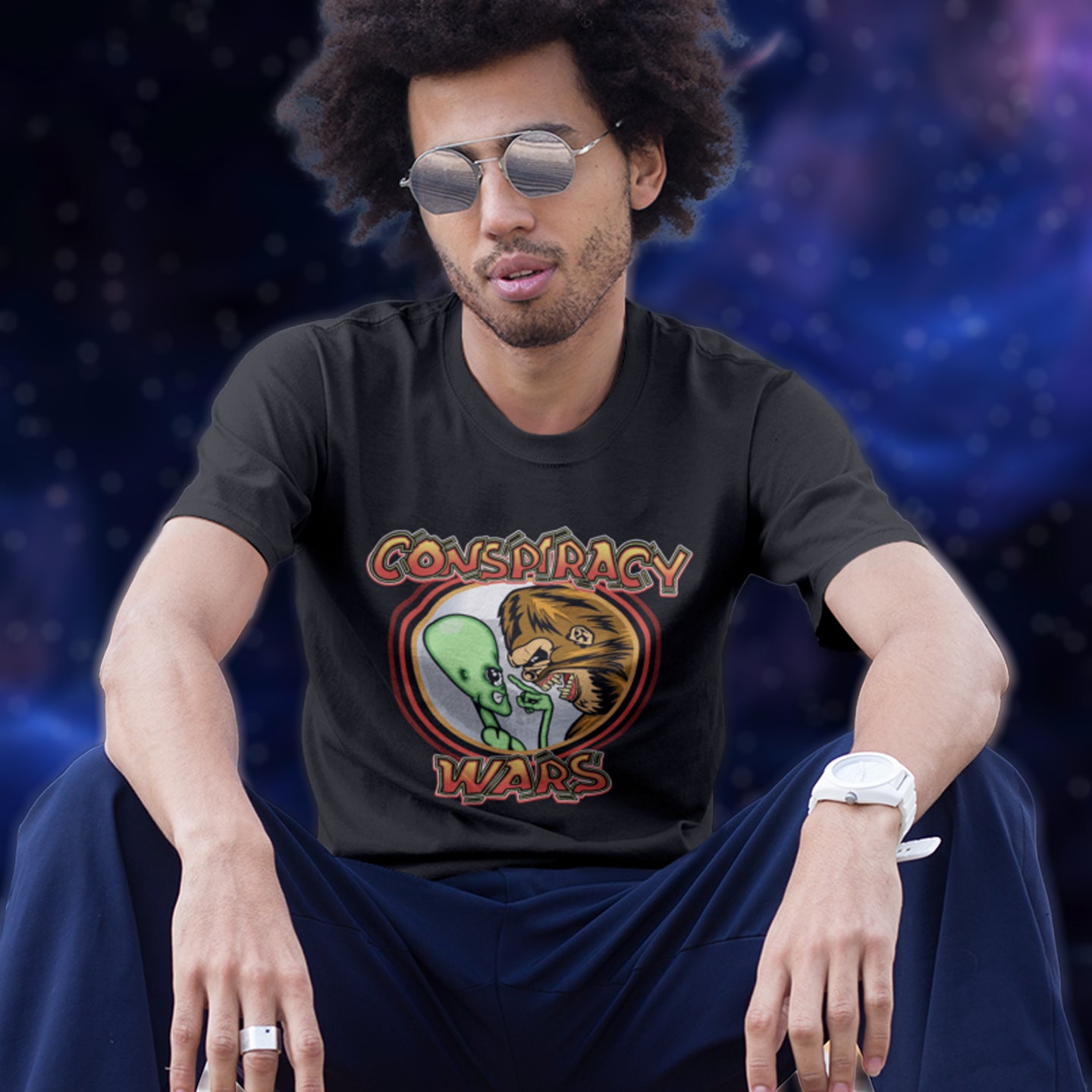 Person wearing a black t-shirt with a graphic design sitting against a dark background. This funny conspiracy t-shirt suggests competition between the two main rivals for cover up stories. Aliens Vs Bigfoot, Kings of conspiracy face off. Made from 100% organic ring-spun cotton, this witty conspiracy theory t-shirt is unisex, high-quality, super comfy, and best of all, eco-friendly.