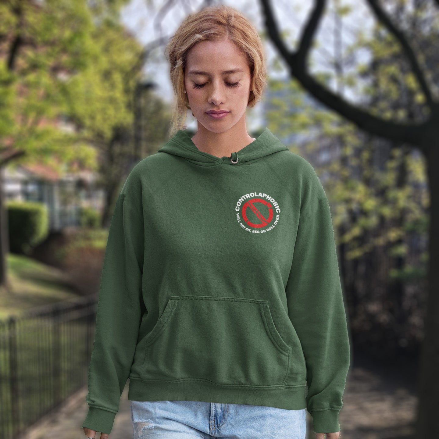 Person wearing a bottle green hoodie with a logo outdoors. A satirical civil rights hoodie suggesting there is a lack of freedom of choice, and too much control, in modern society. If you find yourself unable to follow commands and you're not a dog, You may have controlaphobia. Comfortable and practical. It's extra soft and has a convenient front pouch pocket. Made from organic cotton and recycled polyester, this civil rights hoodie design is a great eco-friendly choice.