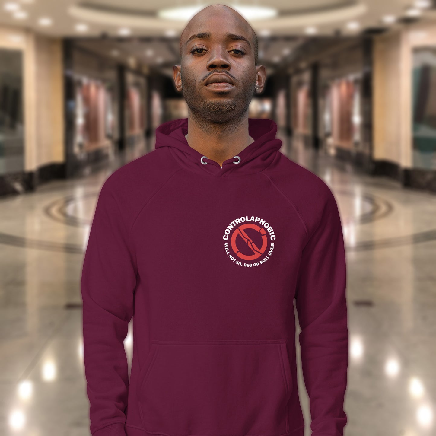Man wearing a burgundy hoodie with a logo in an indoor setting. A satirical civil rights hoodie suggesting there is a lack of freedom of choice, and too much control, in modern society. If you find yourself unable to follow commands and you're not a dog, You may have controlaphobia. Comfortable and practical. It's extra soft and has a convenient front pouch pocket. Made from organic cotton and recycled polyester, this civil rights hoodie design is a great eco-friendly choice.