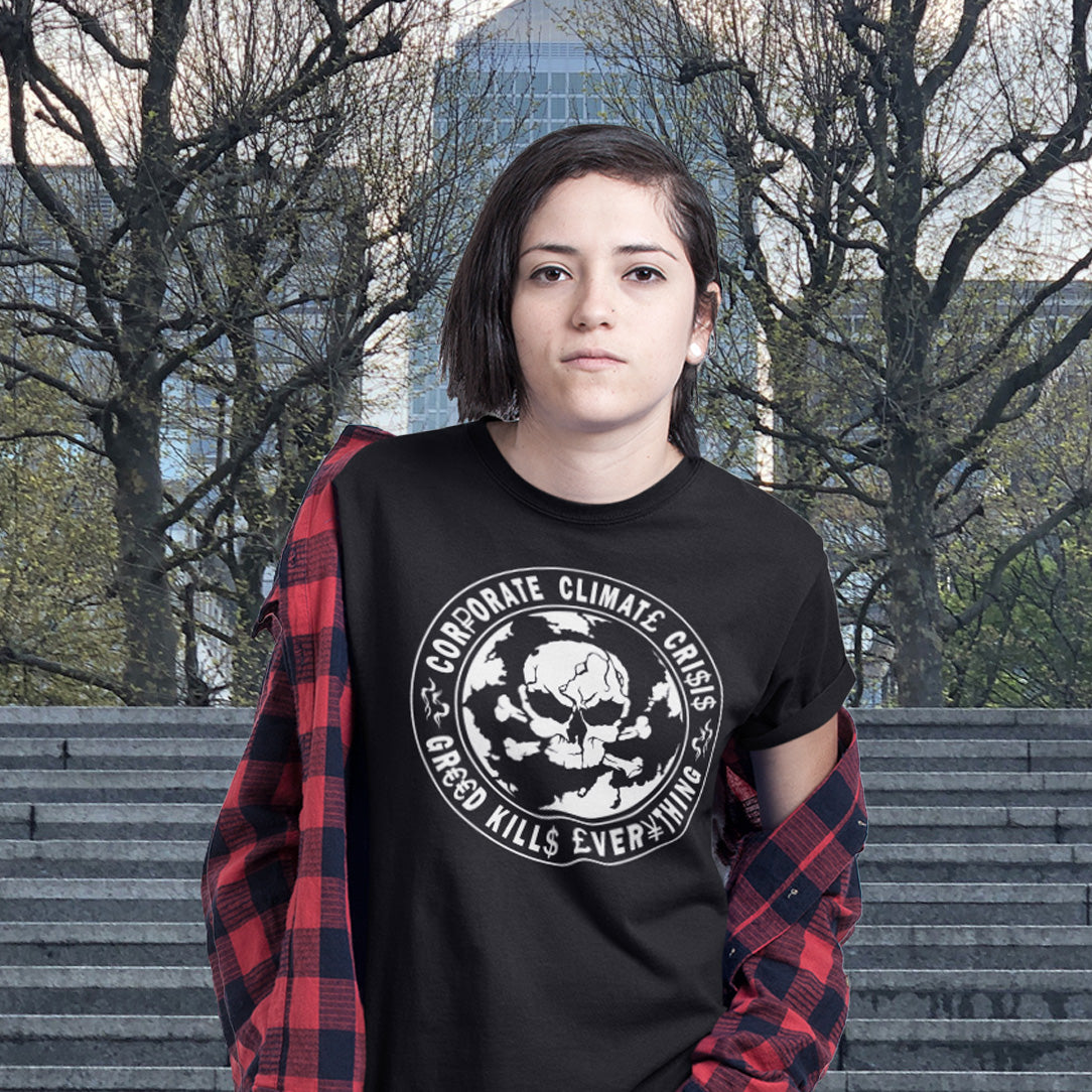 Person wearing a black t-shirt with a graphic design in an urban setting. An anti corporate t shirt encouraging social awareness and support to save our planet from corporate negligence. Make it clear you are no fool to where the climate problem blame should be placed with this original design. Made from 100% organic ring-spun cotton, this save the world t shirt is unisex, high-quality, super comfy, and best of all, eco-friendly.